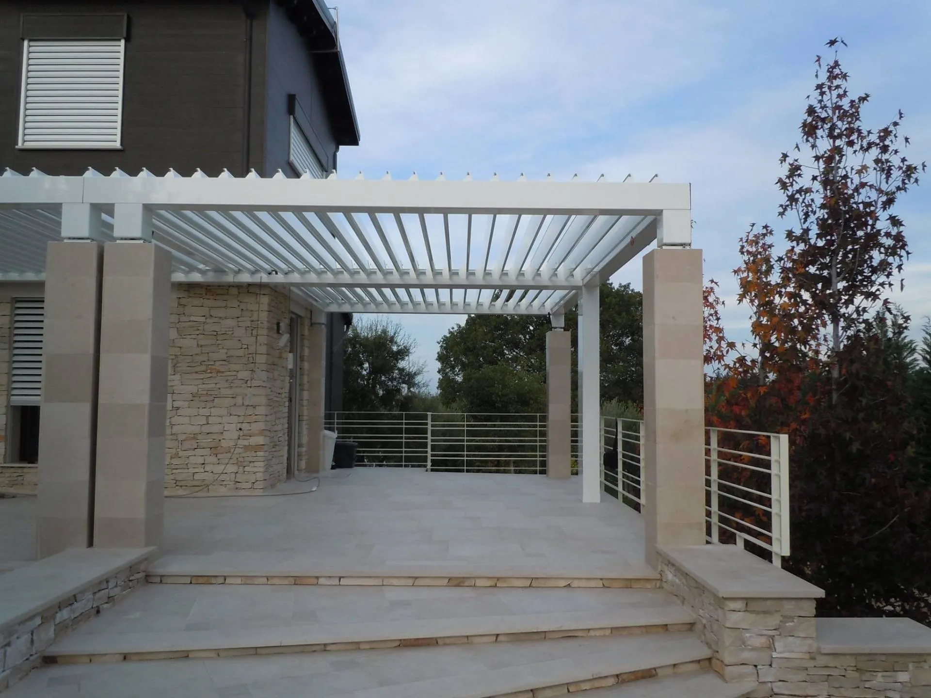 Pergola bioclimatica su terrazza con scalinata in pietra