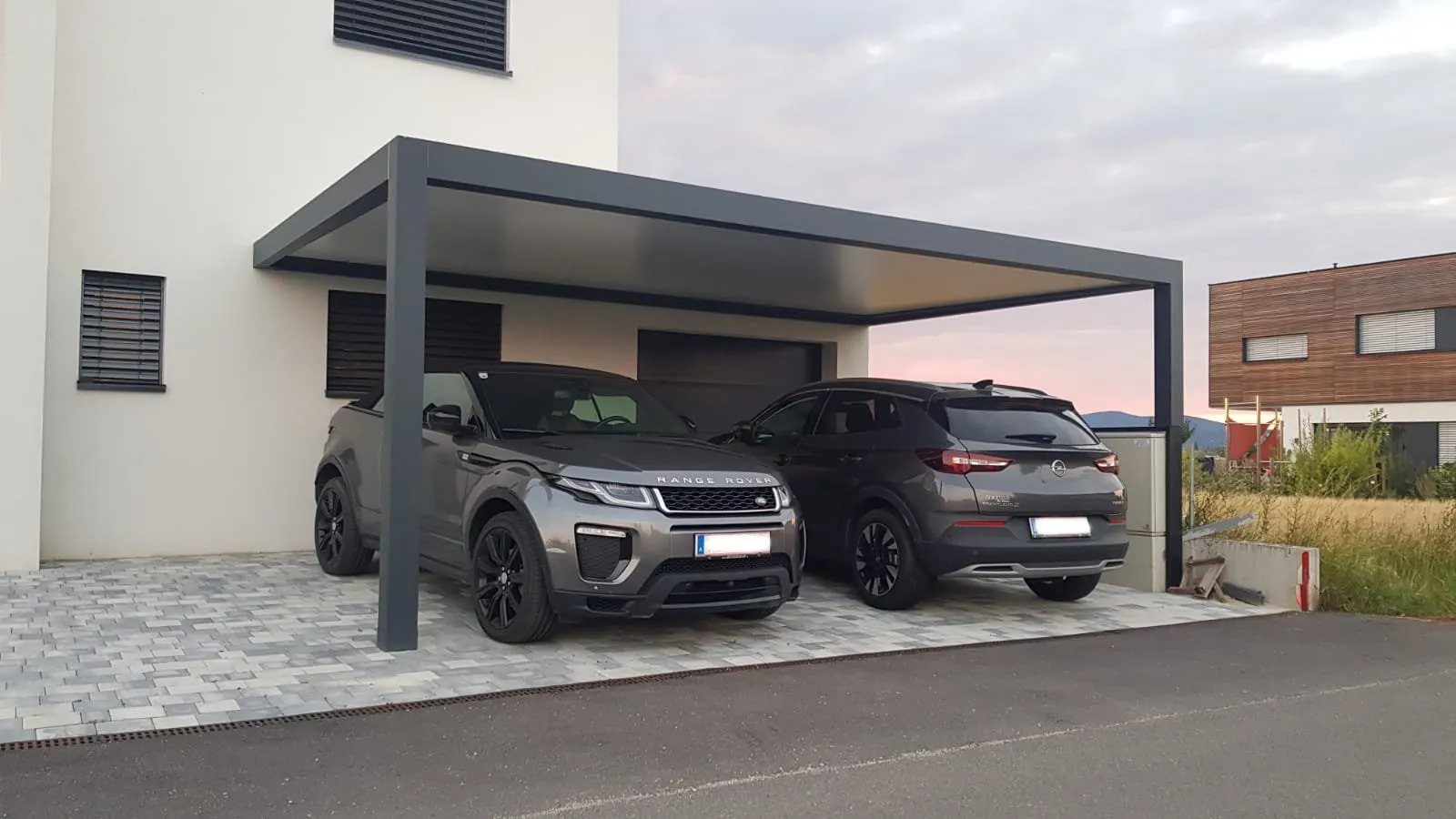 Pergola con tetto fisso usata come carport per due auto